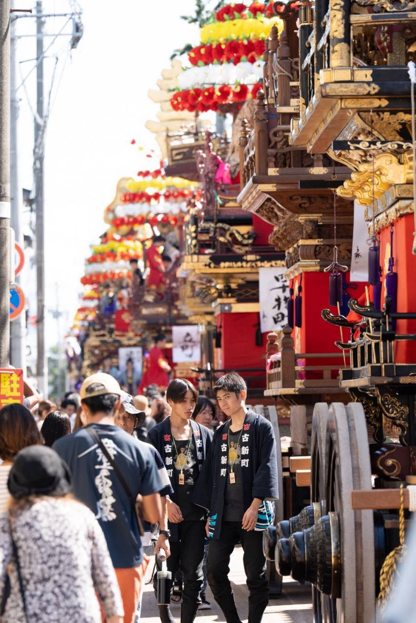 新湊の町に並ぶ華やかな花山と祭りの人々